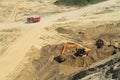 Red truck and excavator in a quarry in sunny day